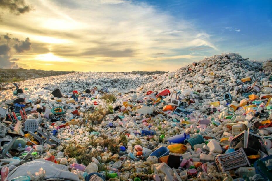 Distesa di rifiuti di plastica in una discarica a cielo aperto al tramonto